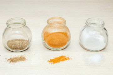 Spices in glass jars. Basil, Provencal herbs, pepper, salt