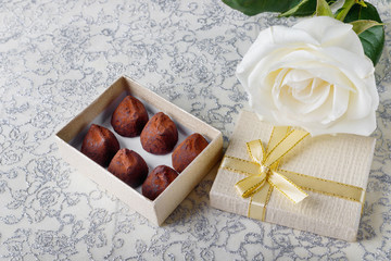 Beautiful white rose with golden gift box and chocolate truffles for Valentine's Day