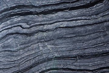A beautiful natural stone background of gray marble with dark stripes is called Silver Wave