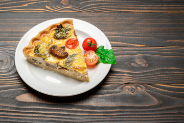 Slice of traditonal homemade spinach chicken quiche tart or pie on plate