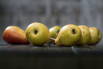 Group of ripe pears on dark rustic wooden table. Side view horizontal shot. Empty copyspace for your design.