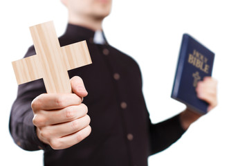 Priest holding a cross and the Holy Bible, isolated on white background