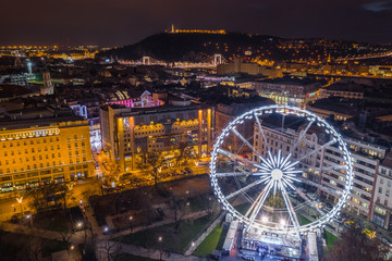Budapest, Hungary - Illuminated ferris wheel at Elisabeth Square at the centre of Budapest with Statue of Liberty, Elisabeth Bridge and other famous landmarks by night