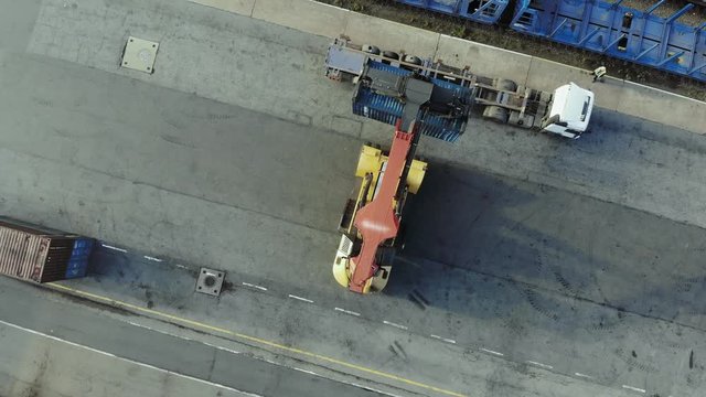 Containers are being lifted on to a block train by means of a transtainer. Aerial, top view.