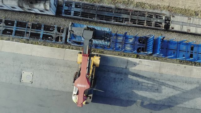 Containers are being lifted on to a block train by means of a transtainer. Aerial, top view.