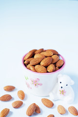 Almond nut in white on white wooden table background