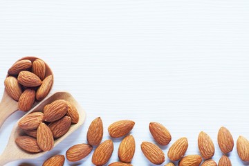 Almond nut in white on white wooden table background