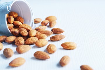 Almond nut in white on white wooden table background
