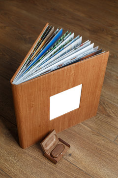 photobook in a leather cover with a photo print
photo album and flash drive on a wooden background