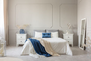 Stylish white, grey and petrol blue bedroom design, copy space on empty wall