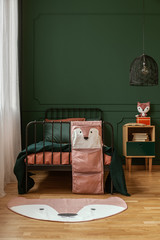 Pastel pink, orange and dark green colors in fashionable kid's bedroom