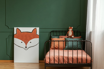White poster with fox next to single metal bed with orange and dark green bedding