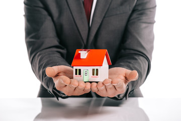 cropped view of mortgage broker holding house model isolated on white