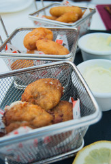 Fried nuggets of meat and fish and potatoes in  small metal baskets