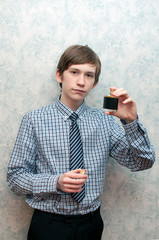The young Russian guy holds a bottle of men's perfumery water in hand.