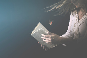woman reads a book where butterflies go out
