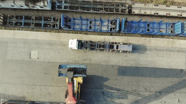Containers are being lifted on to a block train by means of a transtainer. Aerial, top view.