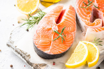 Fresh fish Salmon steak with spices on cutting board.