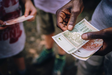 Close up - Händler zählt Geldscheine auf einem Markt in Simbabwe - obrazy, fototapety, plakaty