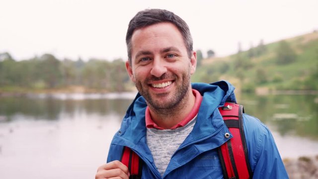 Adult Man On A Camping Holiday Standing By A Lake Smiling, Close Up, Lake District, UK