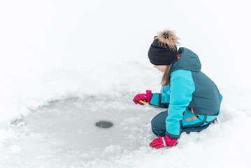 Fototapeta na wymiar child fishing on ice in winter