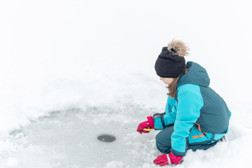 Fototapeta na wymiar child fishing on ice in winter