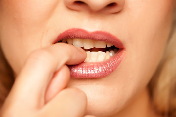 Closeup of woman biting her fingernails