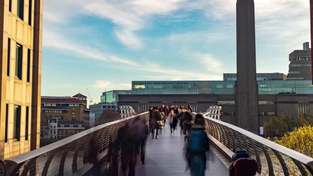 Time lapse view of people crossing the Millennium bridge in London with the Tate modern in the background