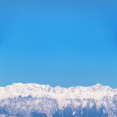 square picture of mountain landscape with snow and blue sky, background picture