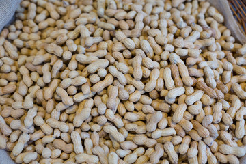 Peanuts in shell texture background. Raw peanuts on display at a farmer's market. Close up image.