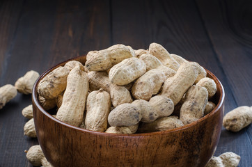 Peanuts in the peel on a dark background.