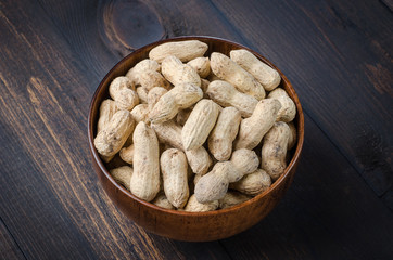 Peanuts in the peel on a dark background.