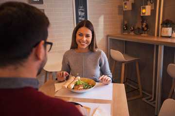 Beautiful girl sitting at restaurant with boyfriend.