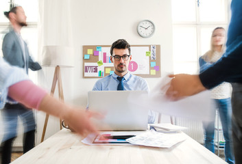 Young businesspeople in a modern office, having meeting. Motion blur.