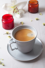 cup of coffee, white lilies and candles.