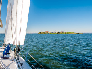 Sailboat sailing to fort island Pampus in IJmeer lake near Amsterdam, Netherlands