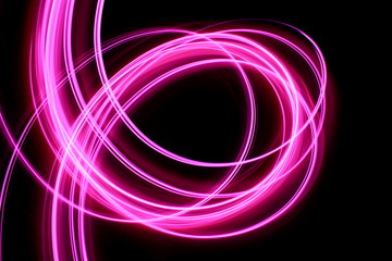Light painting, long exposure photography, vibrant neon pink swirls of color against a black background