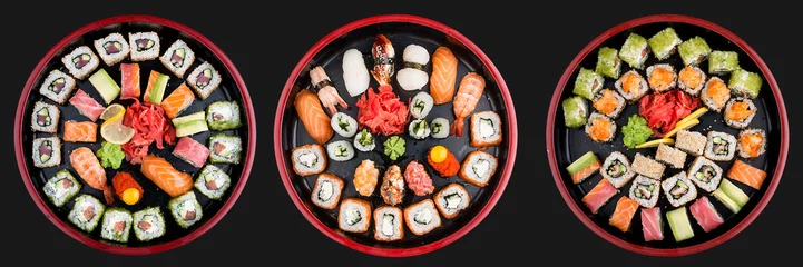 Abwaschbare Fototapete Sushi-bar Sushi-Set Nigiri, Brötchen und Sashimi serviert in traditioneller japanischer schwarzer Sushioke-Rundplatte. Auf dunklem Hintergrund