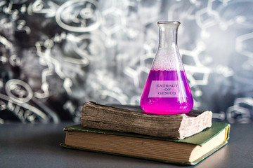 Glass in a chemical laboratory filled with colored liquid during a reaction against the background...