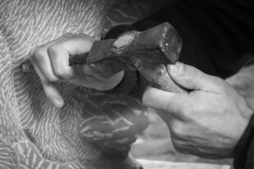 Craftsman hands, working the stone with his tools and blurred background
