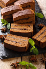 Old Polish ginger cake piernik in plum jam close-up. vertical