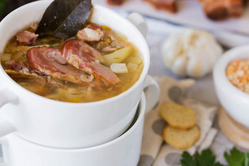Thick pea soup with smoked meats in a white plate