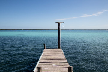 wooden jetty for boats on a blue and blue crystalline Caribbean sea. Caribbean vacation with a...