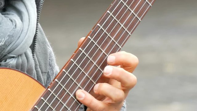 Nuremberg, Germany - December 1, 2018: Street guitar professional playing skillfully playing acoustic guitar in street. Guitarist hands playing a wooden guitar