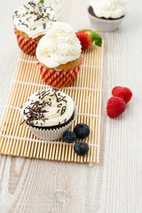 Decorated cupcakes on a wooden table.