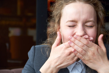 Woman giggles covering her mouth with hand