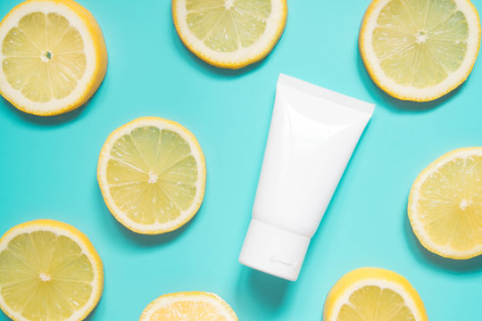 Natural vitamin c skincare product w/ fresh juicy lemon fruit slices on lime green background. Moisturizing cream, facial foam, body lotion w/ lemon extract. Cosmetic beauty product branding mock-up.