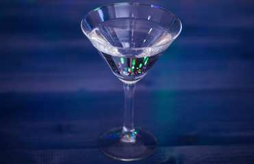 Alcohol cocktail for winter party. Cocktail ideas concept. Easy recipes for winter alcoholic cocktail drinks. What to drink on christmas party. Cocktail glass on blue wooden surface