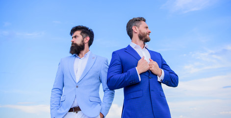 Business men stand blue sky background. Business people concept. Well groomed appearance improves...