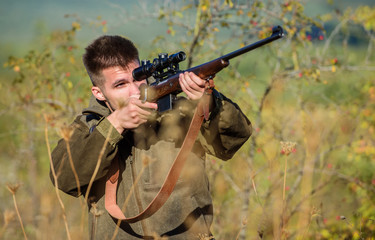 Man aiming target nature background. Aiming skills. Hunter hold rifle. Hunting permit. Bearded hunter spend leisure hunting. Hunting equipment for professionals. Hunting is brutal masculine hobby